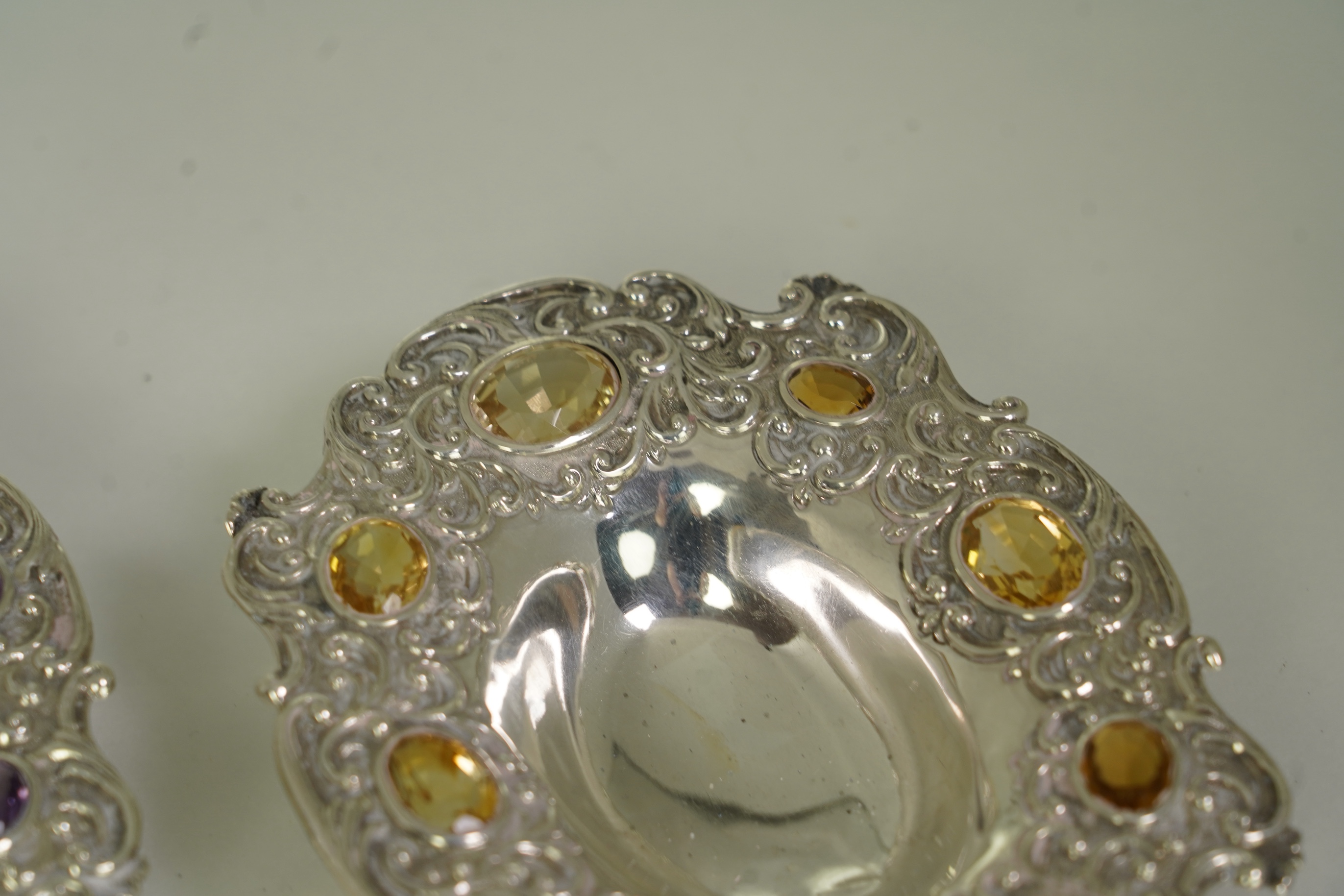 Two unusual late Victorian repousse silver dishes, by Daniel & John Welby, one border inset with eight oval cut amethysts, the other with eight oval cut citrines